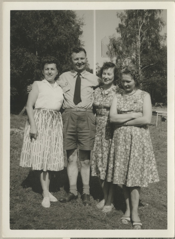 Koosviibimine Göteborgi skautide vabaõhupiirkonnas Koitjärvel, mees ning kolm naist seismas rohuplatsil, grupifoto