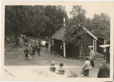 Laager Göteborgi skautide vabaõhupiirkonnas Koitjärvel, skaudijuhid ning skaudid kõndimas pikas rivis  duplicate photo