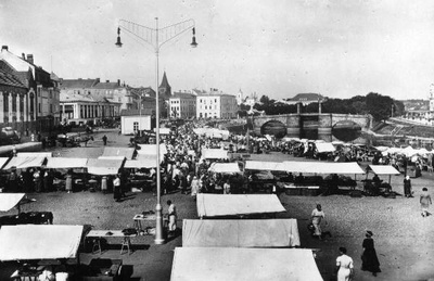 Turg (Söögiturg) Emajõe paremkaldal kaubahoovi ja pritsimaja ees. Kaubaletid, turulised platsil. Taga kesklinn ( Kivisild, Raekoja platsi hooned, Jaani kiriku torn jms). Tartu, ca 1937. Repro: E. Selleke.  duplicate photo