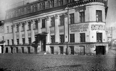 "Bellevue" hotelli hoone Raekoja ja Kalda t nurgal. Esiplaanil Kalda t poolne majakülg, millel on äride reklaamsildid: Raamatu, paberi, pappi ja kirjutusmaterjali kauplus. Wabriku ladu.  ; Puusärgi magasin. Tartu, 1932.  duplicate photo