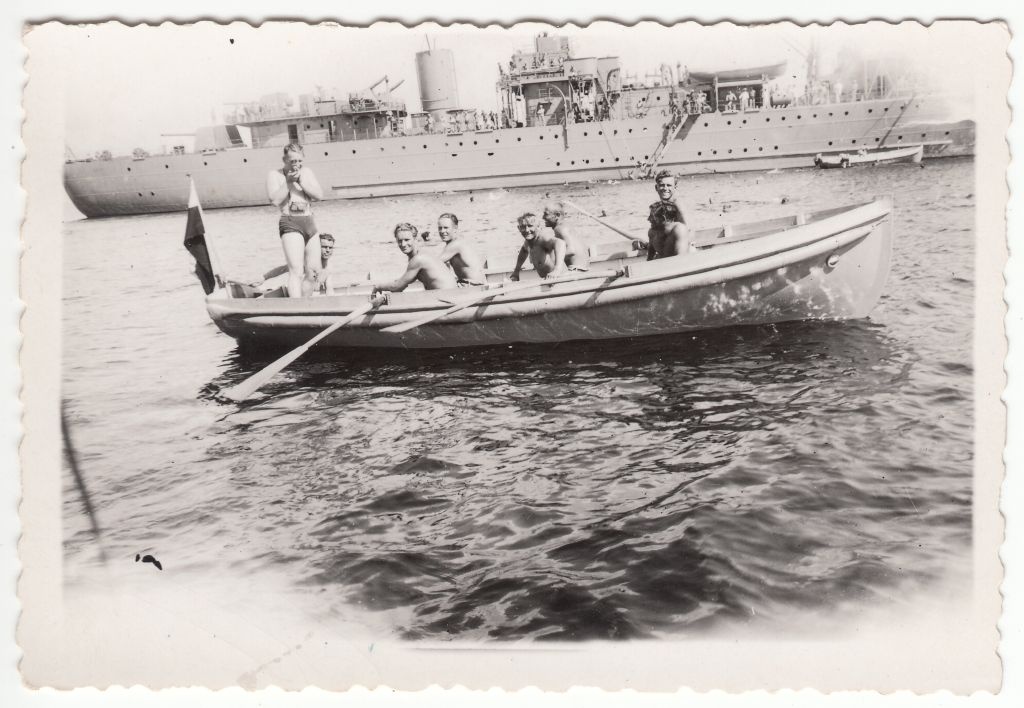 sõjalaeva päästepaat meestega merel, tagaplaanil sõjalaev