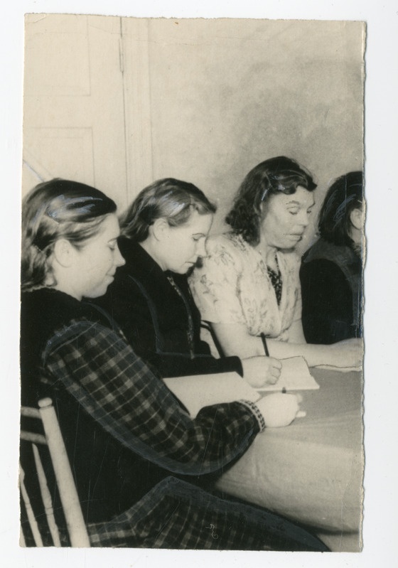 Foto, must-valge. Laua taga istuvad naised