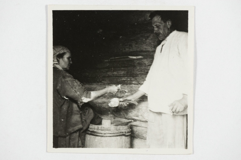 Õlletegemine, mees hoiab tulist kivi, millele naine jahu puistab. Tjapši k