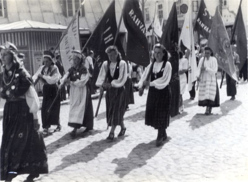 Foto. Läänemaa laulupeo rongkäik Haapsalus Karja t. 5 maja nurgal. Esiplaanil rahvariides naised. 1947.