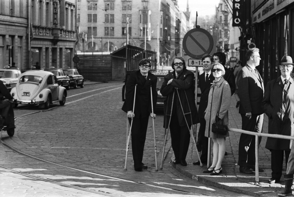 Unioninkatu 27. Two men walking to their gloves and other people on the corner of Union Street and Alexandrian Street before the anti-Wietnam War demonstration moved from the Senate.