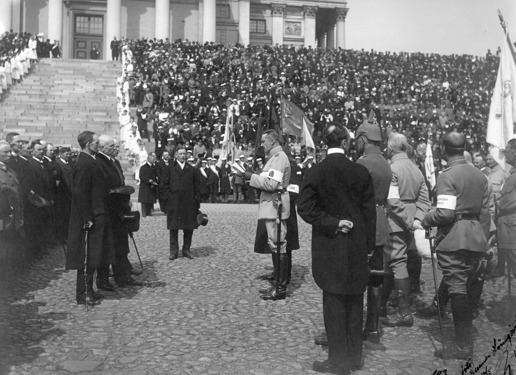 Valkoisen armeijan paraati Senaatintorilla Helsingin valtauksen jälkeen 16.5.1918. Ylipäällikkö kenraali C. G. E. Mannerheim tervehtii eduskunnan puhemiehiä ja eduskuntaa. Mannerheimin edessä puhemiehet S. Alkio, Lundson ja Ingman.