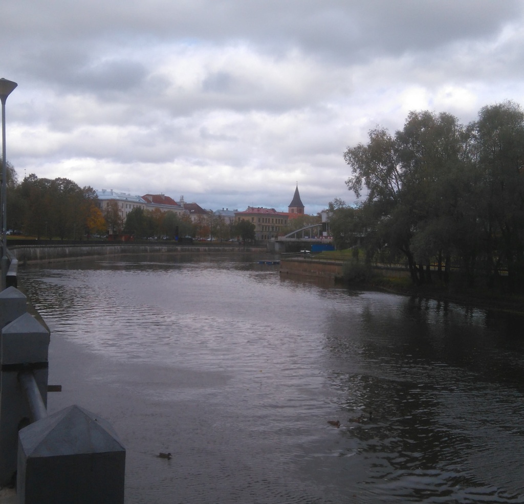 Puzzlers at the Emajõe. View from the shore of Emajõe towards the Kitchen Market towards NW. The tower of the Yann Church in the back. rephoto