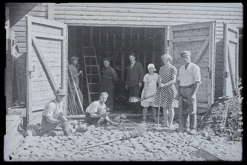 Grupp inimesi puitehituse ees kivisillutist tegemas, (foto tellija Luter).
