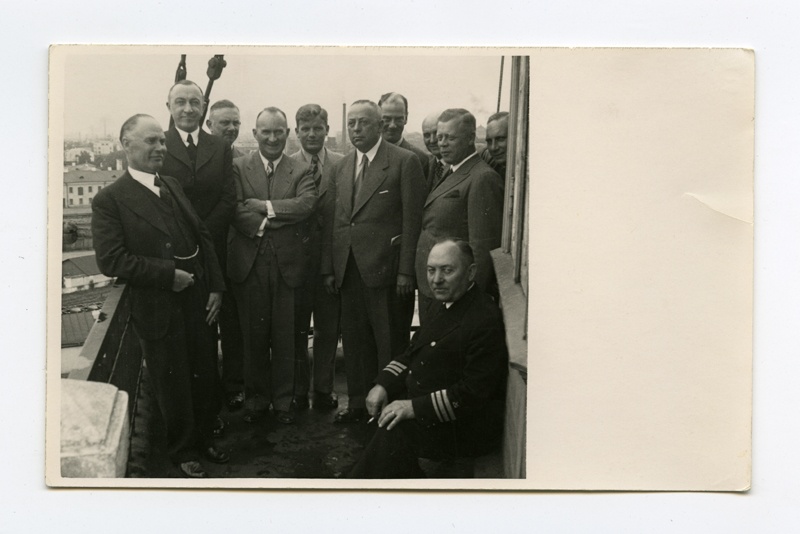 Saksamaa Kaubandus-Tööstuskoja esindus Eesti Veeteede Valitsuses külaskäigul.
Grupifoto.
Paremal istub vormis kapten Avo Heinmaa, tema taga seisab direktor Eduard Johannes Avik.
Tallinn, Eesti Veeteede Valitsuse hoone tornis.
1938