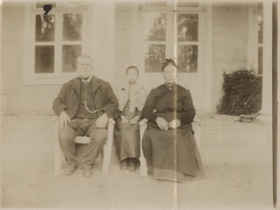 Perekond maja ees istumas. Mees, naine ja tütar  duplicate photo