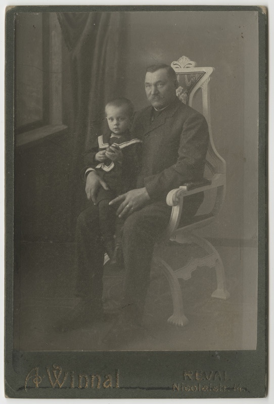 Mees toolil koos väikse lapsega toolil istumas