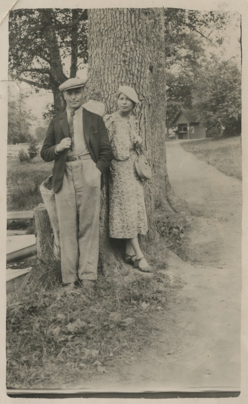 Oskar ja Helene Vares seismas puu juures, mille kõrval olev teerada viib väikse majani