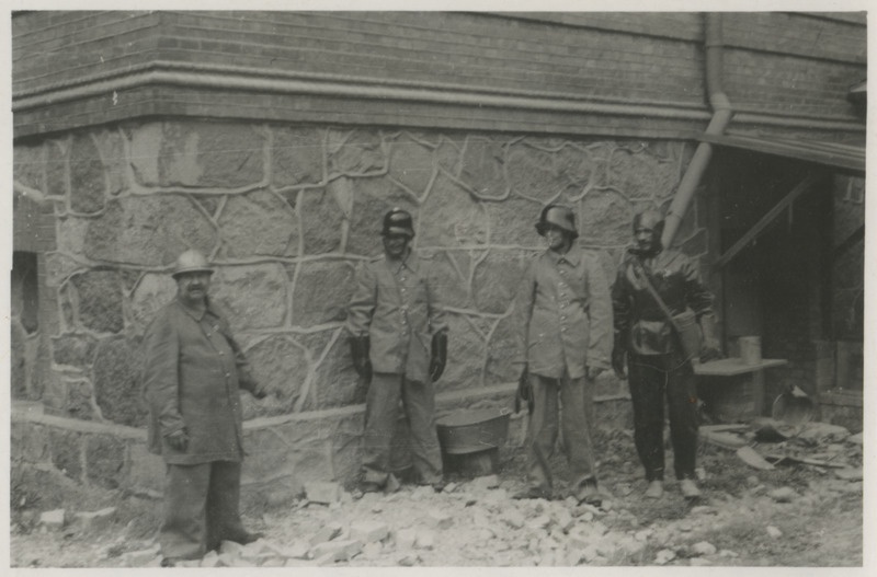 Tuletõrje ja gaasikaitse varustuses arhiiviteenistujad Tartu lahingu ajal 12 juulil mürsutabamusest tekkinud kiviprügi juures seismas