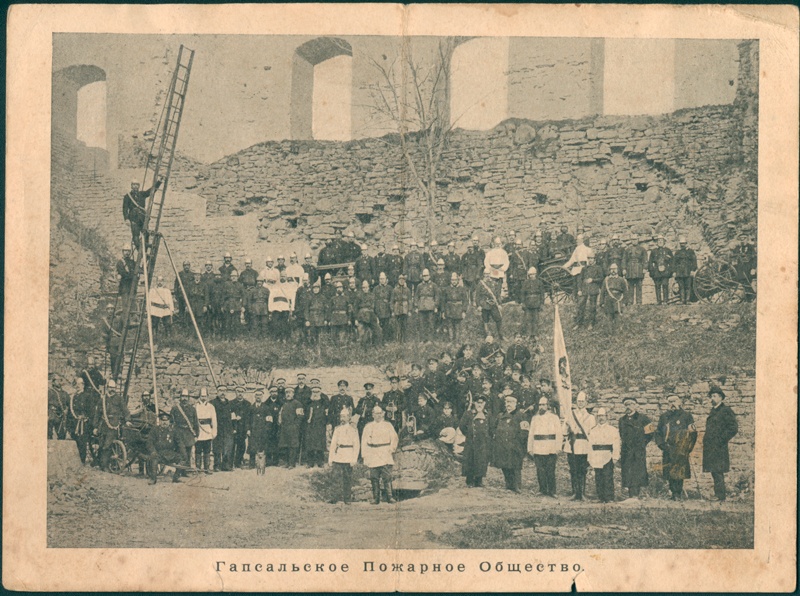 Haapsalu VTS liikmed lipu ja tuletõrjevarustusega lossivaremete ees