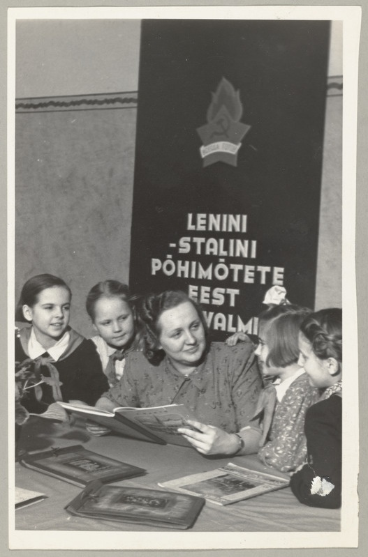Seeria: "Fotosid Eesti NSV-st mitmesugustelt elualadelt". Tartu Linna 4. mittetäieliku keskkooli direktor, ENSV Ülemnõukogu saadikukandidaat Juta Kotsar vestlemas kooli pioneeride grupiga.