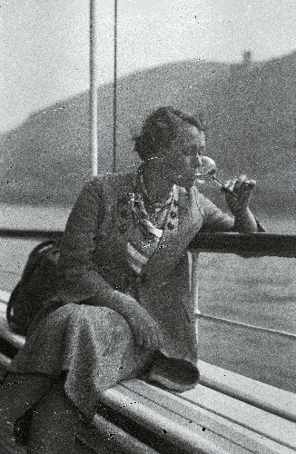 Daam pokaaliga (Lore von Krusenstiern?). Naine istub jõelaeva reelingu ääres.