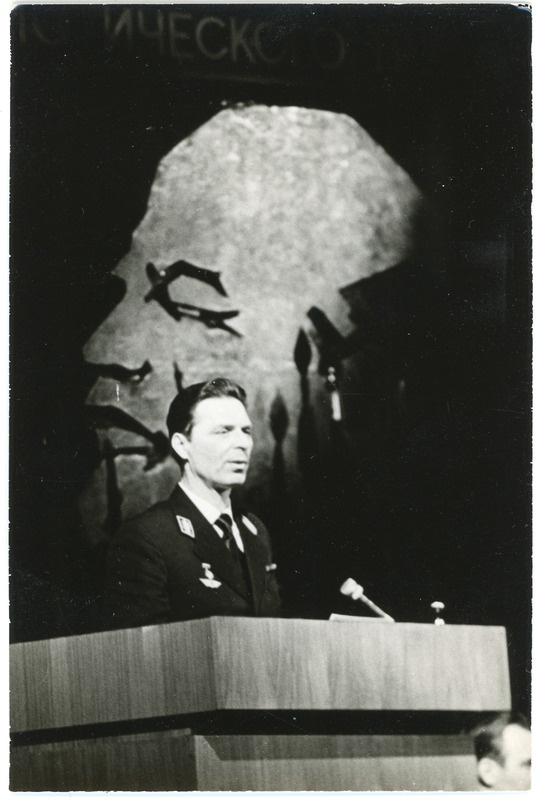 Eesti Raudteekonna kollektiivile NLKP KK, NSVL Ministrite Nõukogu, ÜAÜKN ja ÜLKNÜ KK rändpunalipu üleandmise pidulik koosolek: presiidiumi liige kõnepuldis, 28.02.1975, foto: Mihkel Ollino