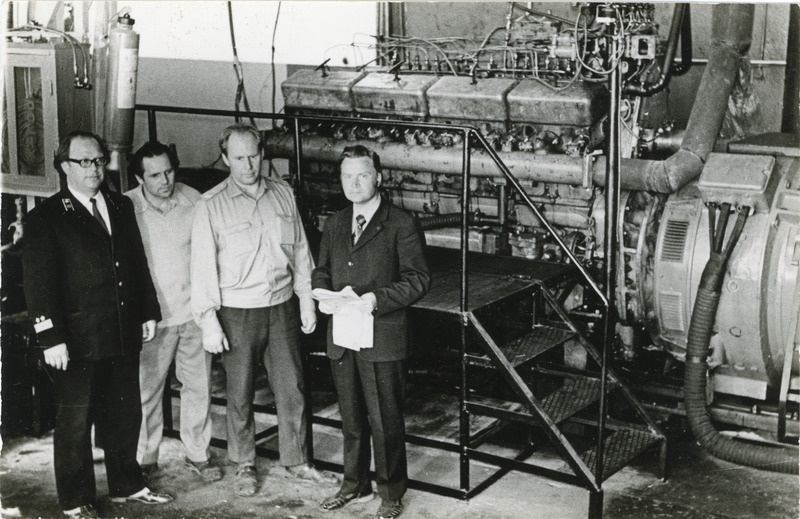 Tallinna veduridepoo ühiskondliku konstrueerimisbüroo liikmed enda konstrueeritud VME1 vedurite diiselmootorite katsestendi ees, vasakult esimene depoo peainsener Vadim Kiritšenko, 1. juuli 1975, foto: Mihkel Ollino