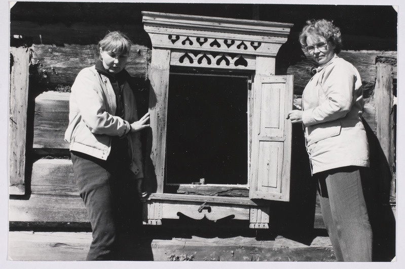 Kaunistatud aken. Akna kõrval seisavad ERM-i osakonnajuhataja Mare Piho (vasakul) ja soome etnograaf Marjukka Patrakka.