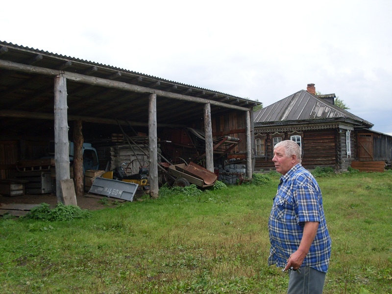 Peremees (eestlane) oma pere majapidamises, vasakul varjualune, paremal eluhoone. Tomski oblasti eesti küla Lillengof