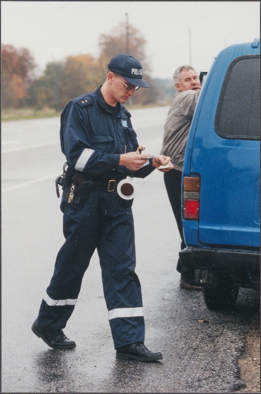 Liikluspolitseinik maanteel dokumente kontrollimas.
