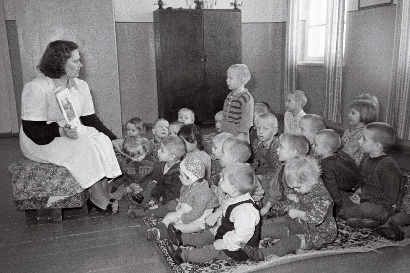 Rahnoja sovhoosi lasteaia juhataja J. Jakobson lastele pildiraamatut näitamas.