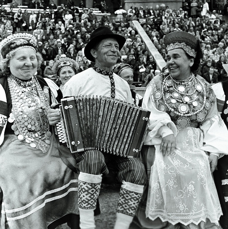 Eesti NSV teeneline kultuuritegelane Laine Mesikäpp (paremal) rahvatantsupeol lõõtspilli mängijaga vestlemas.