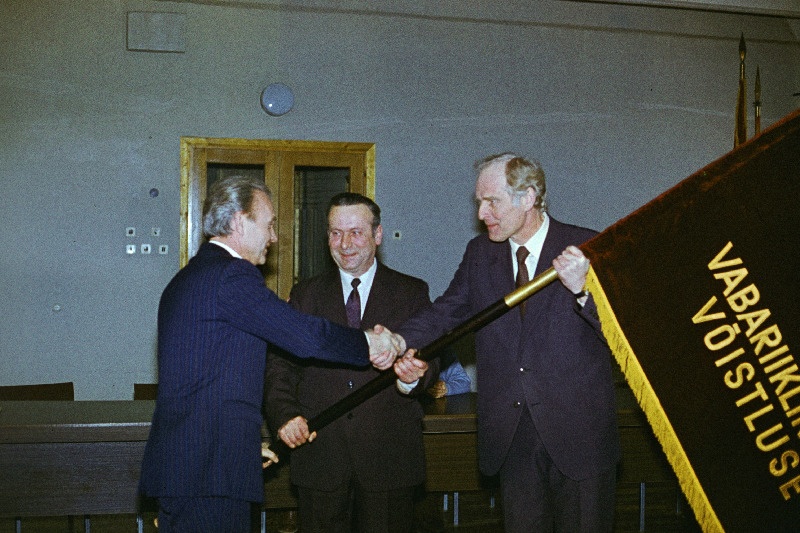 1986.a IV kvartali töötulemuste eest Võru Autobaasile nr 3 ja Võru raudteejaamale määratud vabariigi sotsialistliku võistluse võitjalipu annab autobaasi direktorile Avo Kilgastile ja raudteejaama ülemale Nikolai Satskile üle Eesti NSV autotranspordi- ja maanteede minister Garald Kruger.