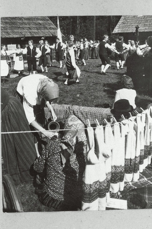 Kihnu naiste käsitööde näitus Eesti NSV Riiklikus Vabaõhumuuseumis. Tagaplaanil tantsivad soome rahvatantsijad.