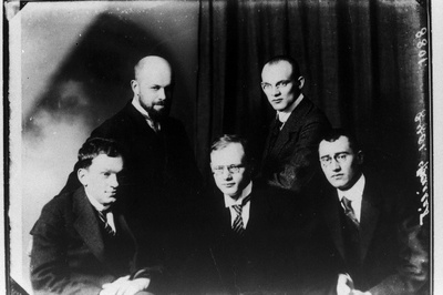 Istuvad vasakult: jurist Hans Martna, kirjanik August Gailit, matemaatikaõpetaja Eduard Nipman; seisavad: kunstnik Nikolai Triik (vasakul) ja õigusteadlane Richard Rägo[Räägo].  duplicate photo