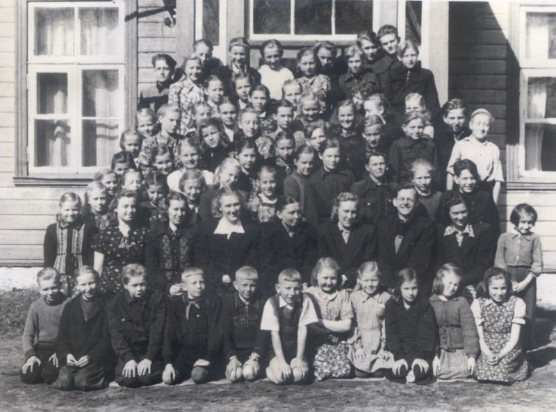 Foto. Koolipere Piirsalu 7.-a. koolimaja taustal 1954. a. kevadel.  Asub HM 7623.