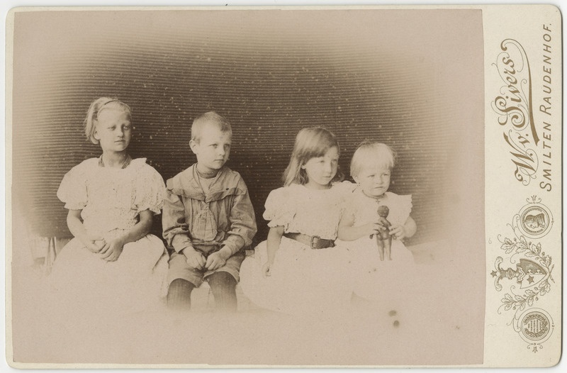 Neli istuvat last, grupifoto