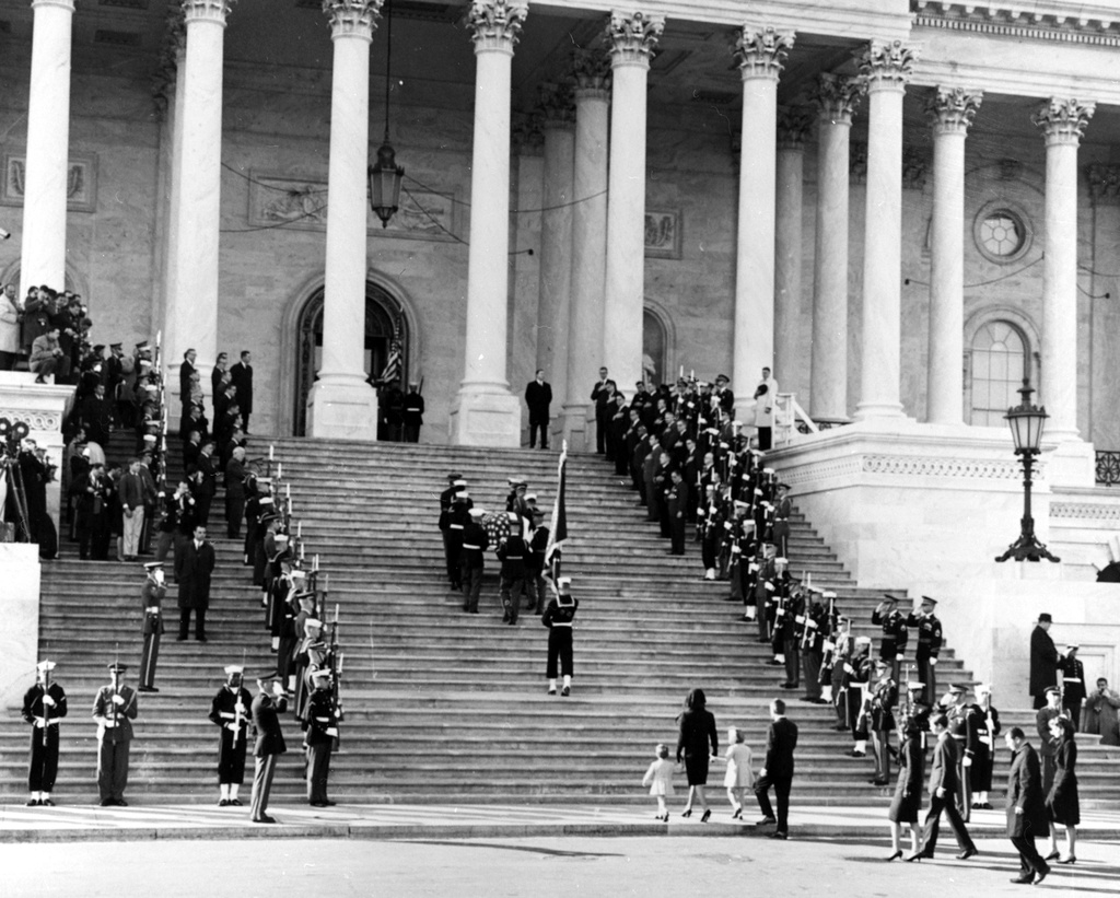JFK casket up Capitol steps, 1963 - Photograph of servicemen carrying the casket of President John F. Kennedy up the steps of the Capitol, followed by the late President's widow and children, during state funeral services for President Kennedy in Washington.