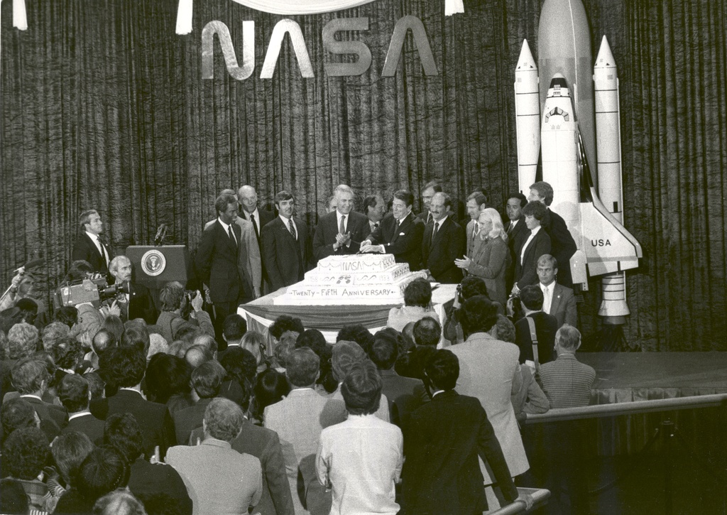 NASA 25th anniversary celebration at the National Air and Space Museum, October 19, 1983 - President Ronald Reagan addressed NASA employees during NASA's 25th Anniversary celebration at the National Air and Space Museum, October 19, 1983. 
On stage, around the cake (left to right) are: astronauts Guion Bluford and Dale Gardner (hidden); Dr. William Thornton; Daniel Brandenstein; Richard Truly (hidden); James M. Beggs, NASA Administrator; Dr. Norman Thagard; President Ronald Reagan; John Fabian; Frederick Hauck; David Walker; Dr. Rhea Seddon; Ellison Onizuka; Dr. Anna Fisher; Dr. Steven Hawley.