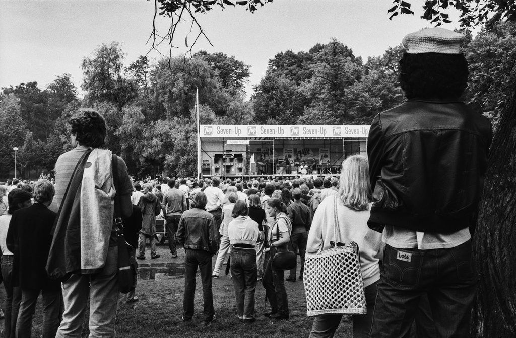 Kaivopuiston konsertin yleisöä katselmassa ja kuuntelemassa esiintyjää