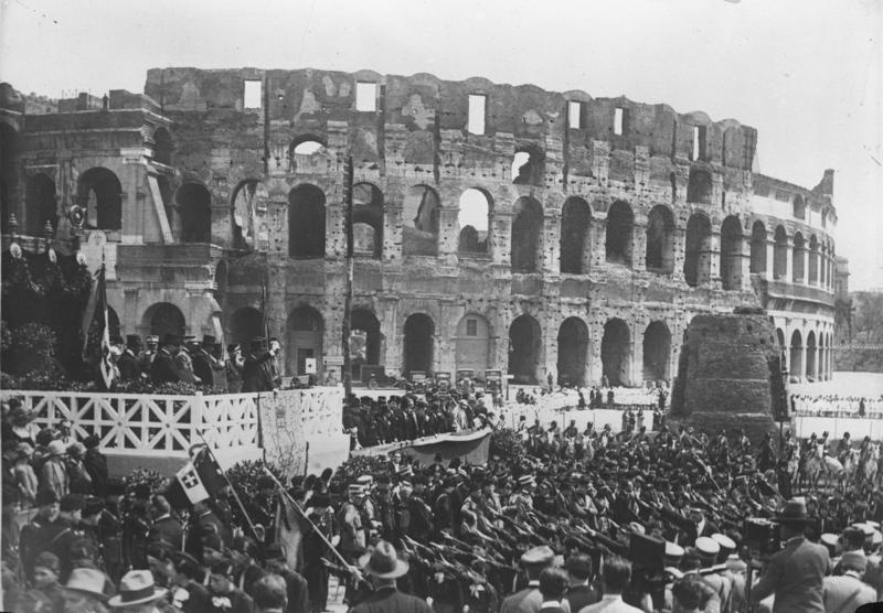 Rom, Ansprache Mussolinis an die Jugend - For documentary purposes the German Federal Archive often retained the original image captions, which may be erroneous, biased, obsolete or politically extreme. Der italienische Diktator Mussolini spricht vor dem alten Collosseum in Rom zur faszistischen Jugend seines Landes.
Mussolini auf der Tribüne (links im Bilde) vor dem Collosseum in Rom beim Vorbeimarsch der faszistischen Jugendverbände.