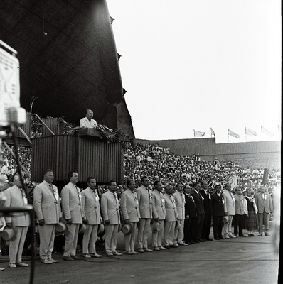 Juubelilaulupeo üldjuhid (vasakult): 1. V. Lemmik (?), 2. L. Karindi, 3. K. Areng, 4. A. Pajupuu, 5. H. Uibo, 6. A. Stepanov, 7. A. Velmet, 8. A. Kiilaspea, 9. H. Rannap, 11. J. Tungal, 12. N. Järvi, 13. H. Orusaar, 14. U. Järvela (?), 15. A. Ratassepp, 16. H. Kaljuste, 17. L. Verlin. Kõneleb üldlaulupeo peakomisjoni esimees A. Green.  similar photo