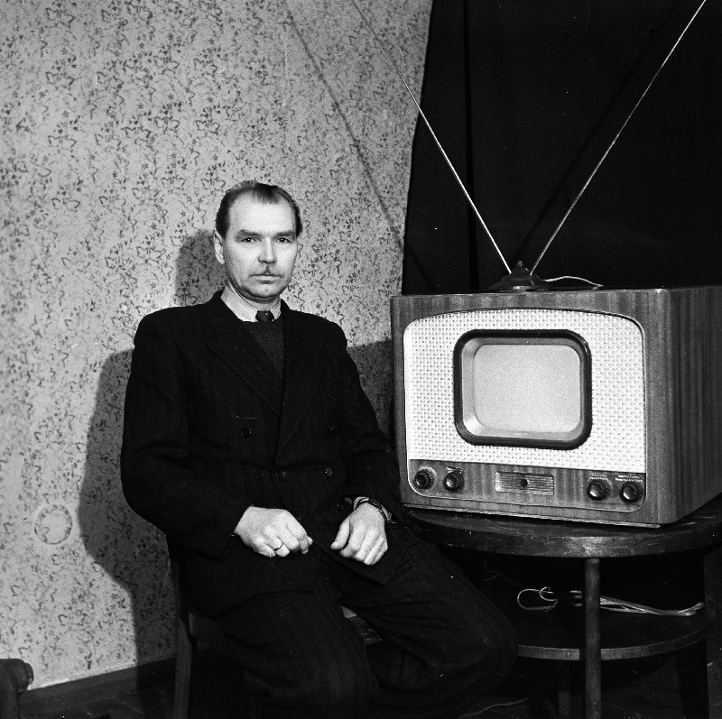 Mees televiisori ees istumas.