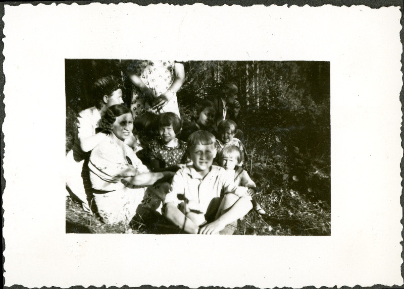 Grupp inimesi metsas istumas ja vestlemas