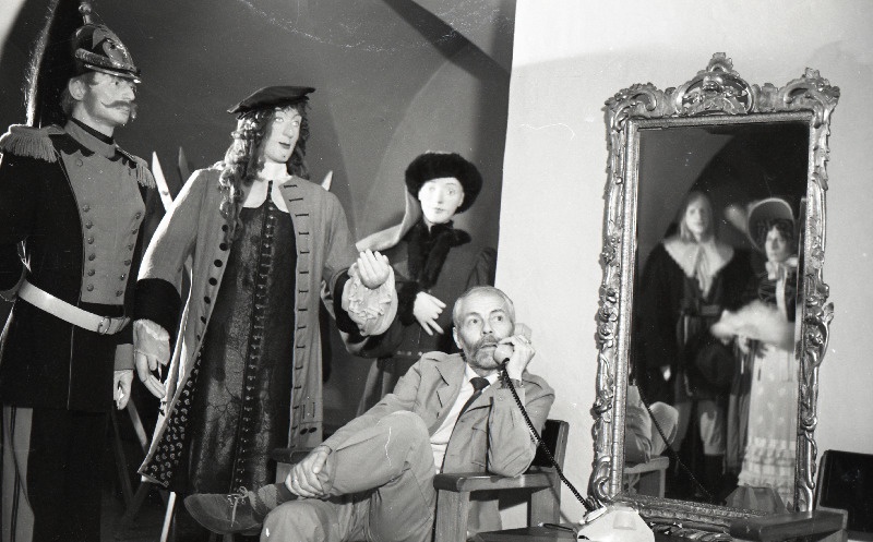 Tõnu Aru poseerimas telefoniga keskaegselt riietatud figuuride keskel