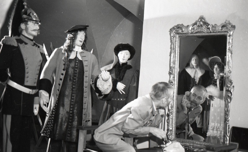 Tõnu Aru poseerimas telefoniga keskaegselt riietatud figuuride keskel