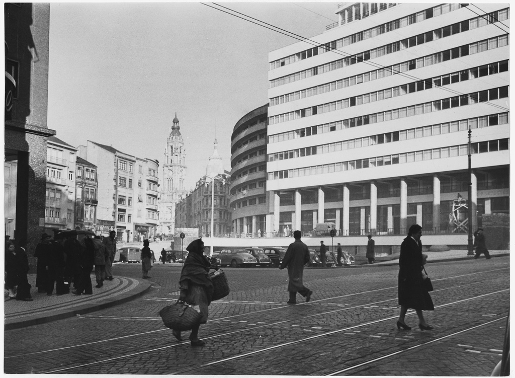 Oporto, Portugal. Oporto street secen. The old city is represented in this picure by the bell tower in background, and street peddlers with baskets - in contrast to the new buildings, modern cars, street railways