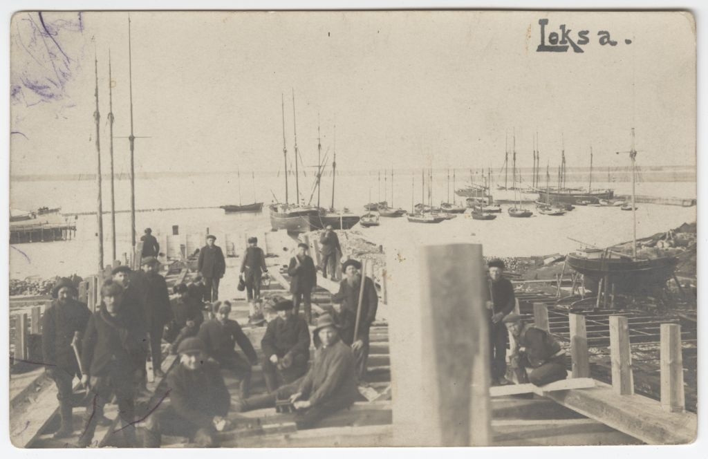 Töölised Loksal staaplil. Sadamas purjelaevad.