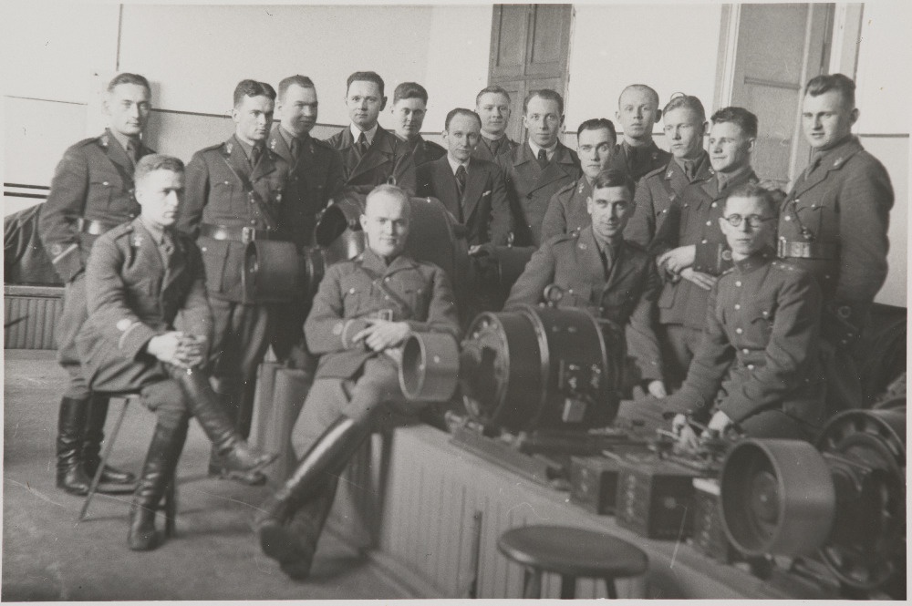 Eesti Vabariigi Sõjaväe Tehnikakool.Pürotehnikaklass elektrotehnika praktikumis.Istuvad vasakult lipnikud M.Purgas, A.Aarna, leitnandid J.Liiv ja P.Värk. Seisavad vasakult lipnikud K.Rõngelep, J.Luiker, E.Arumeel, TTÜ instruktorid  A.Vahari ja A.Pehka, H.Maidre. V.Karuse, J.Seks, O.Kornet, J.Priikask, I.E.Sepp, V.Anvelt, K.Saare.