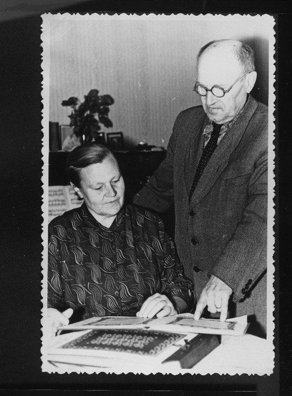 Õpetaja - pensionär, endine Tõrva Keskkooli lauluõpetaja J. Hanson näitab pensionärile S. Käspertile autasusid, mis ta on saanud tubli töö eest koorijuhina.