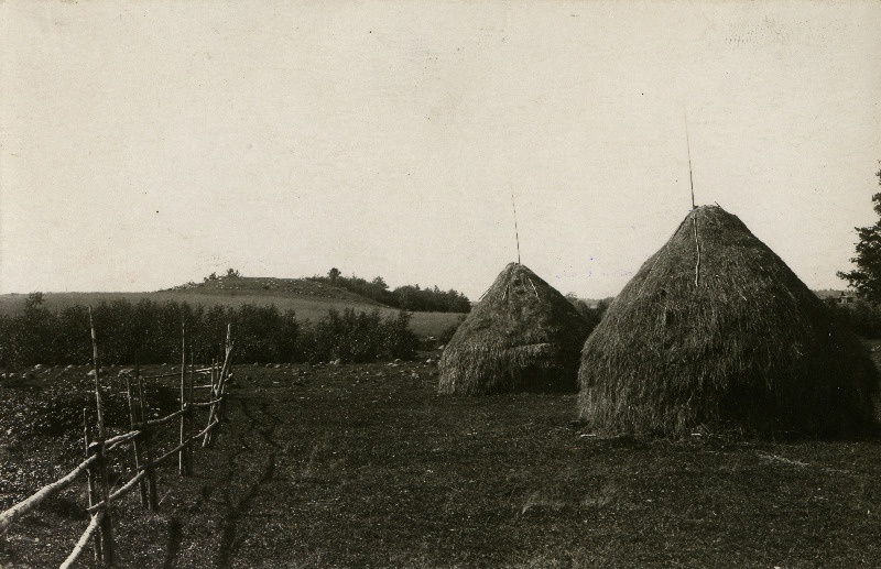 Prigi kalmemägi Tohvri talu juures. Ees talu heinakuhjad.