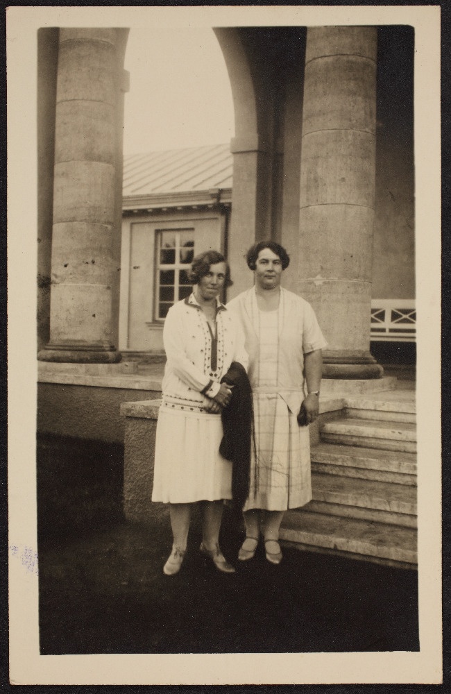 Hilda Tõnisson tundmatu naisterahvaga hoone ees.