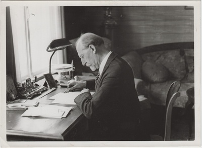 Jaan Tõnisson kirjutuslaua taga pabereid uurimas.  duplicate photo