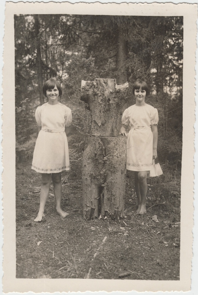 Kaks tüdrukut kändudest ehitatud kuju juures.