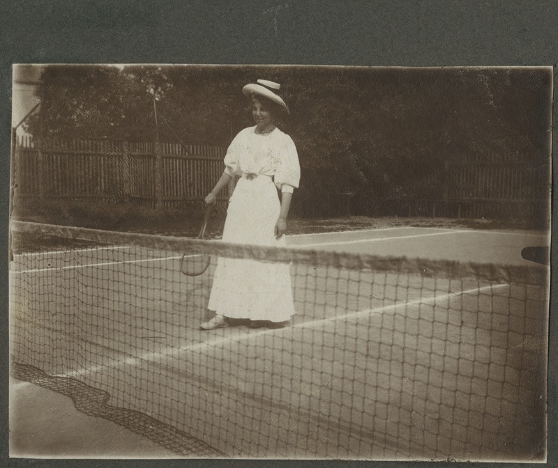 Noor valges kostüümis naine tennist mängimas